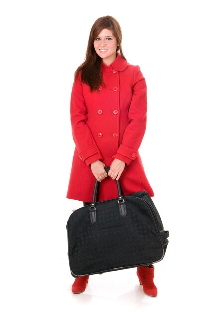 Jolie femme en manteau rouge avec sac ou valise sur fond blanc