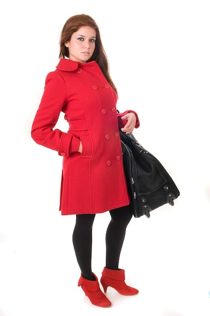 Jolie femme en manteau rouge avec sac ou valise sur fond blanc