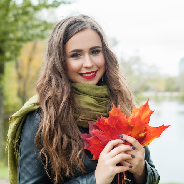 Jolie femme marchant dans le parc d'automne en plein air