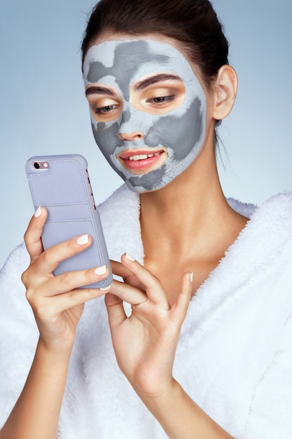 Jolie femme avec un masque d'argile sur son visage