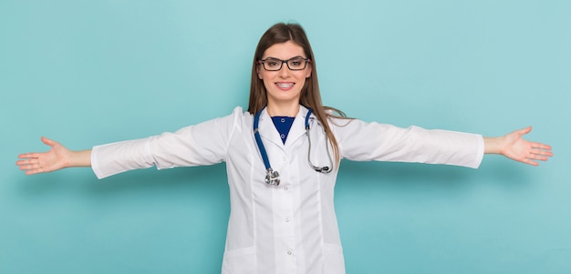 Jolie femme médecin en blouse blanche et lunettes