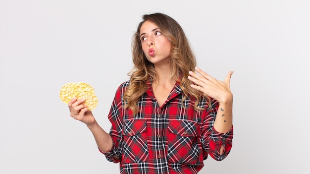 Jolie femme mince se sentant stressée anxieuse fatiguée et frustrée et tenant un régime de gâteaux de riz