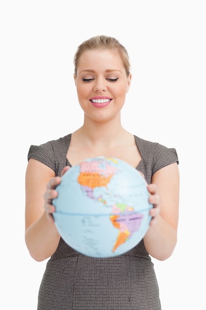 Jolie femme montrant un globe