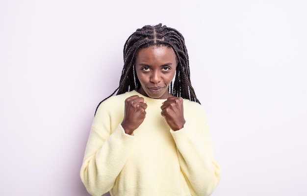 Jolie femme noire à l'air confiante, en colère, forte et agressive, avec les poings prêts à se battre en position de boxe