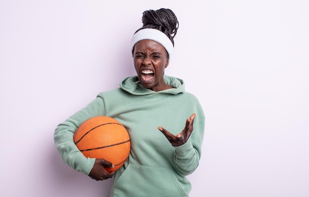 Jolie femme noire semblant en colère, agacée et frustrée. concept de basket-ball