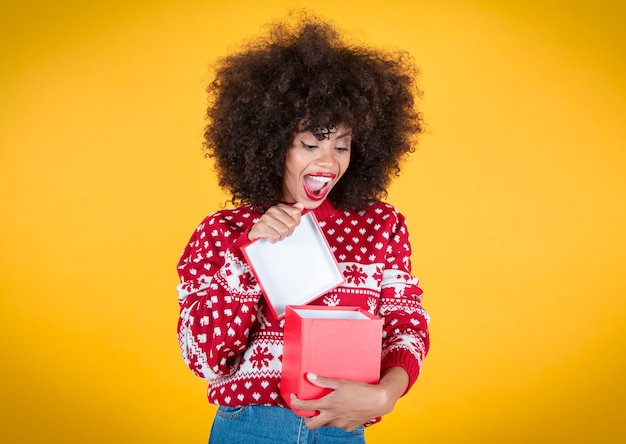 jolie femme ouvrant le cadeau de noël, heureux, fond jaune