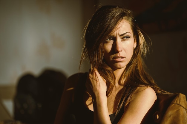 Une jolie femme pensive assise et fronçant les sourcils regardant loin un matin ensoleillé.