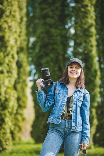 Jolie femme photographe tenant un appareil photo professionnel