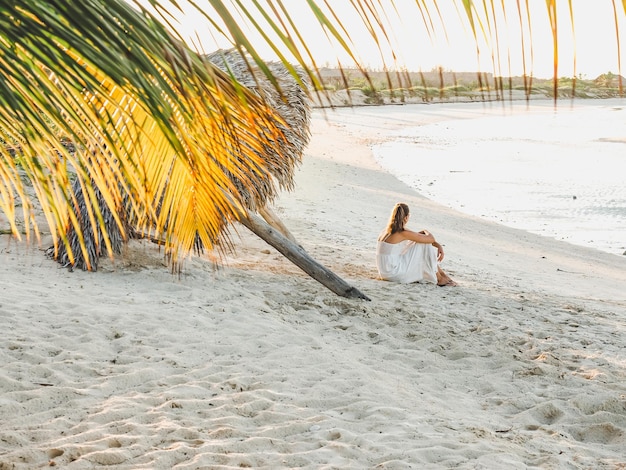 Jolie femme sur la plage dans le contexte de la mer