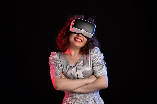 Jolie femme portant un casque de réalité virtuelle sur une surface sombre