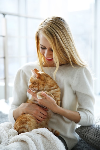 Jolie femme posant avec chat rouge