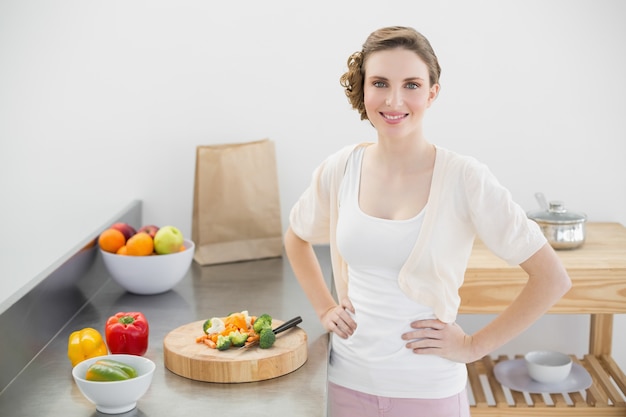 Jolie femme posant dans sa cuisine avec les mains sur les hanches