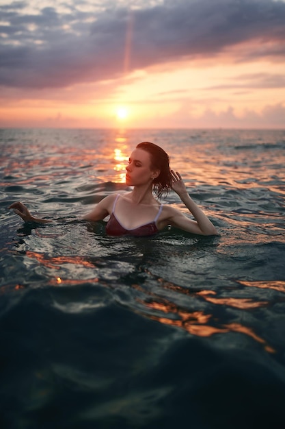 Jolie femme pose sur le fond de l'incroyable coucher de soleil