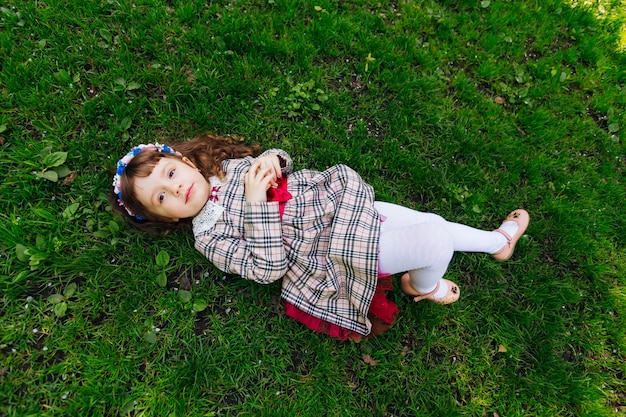 Une jolie femme pose sur une herbe verte dans une belle robe