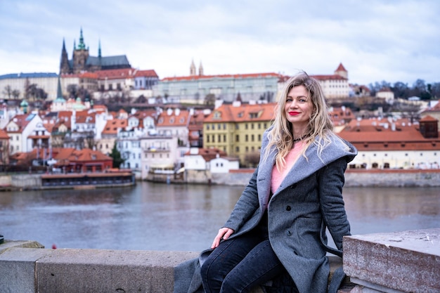 une jolie femme pose pour l'appareil photo, à Prague sur le pont Charles