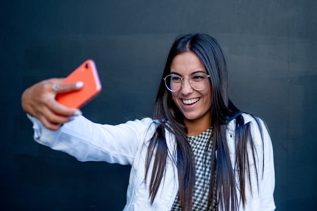 Photo jolie femme pose et prend une photo avec un téléphone portable.