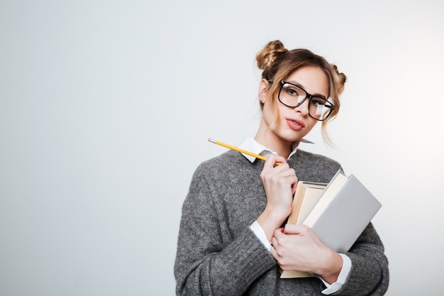 Jolie femme en pull et lunettes avec des livres