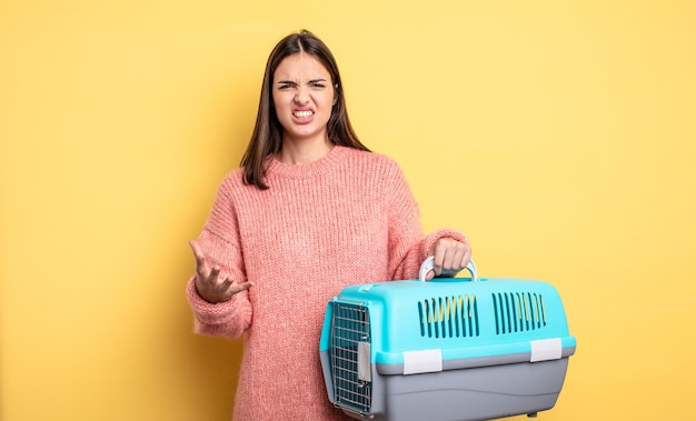 Jolie femme qui a l'air en colère, agacée et frustrée. concept de transporteur pour animaux de compagnie