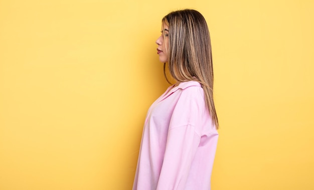 Jolie femme de race blanche sur la vue de profil cherchant à copier l'espace devant, à penser, à imaginer ou à rêvasser