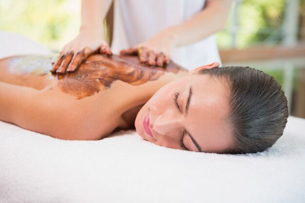 Jolie femme recevant un masque de chocolat au centre de spa