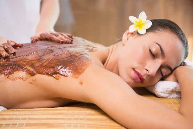 Jolie femme recevant un masque de chocolat au centre de spa