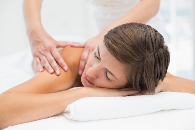 Jolie femme recevant un massage des épaules au centre de spa