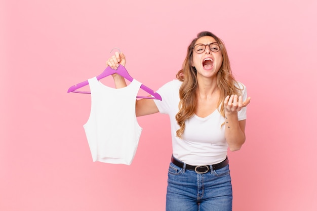 Jolie femme à la recherche désespérée, frustrée et stressée et choisissant des vêtements