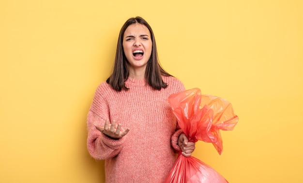 Jolie femme à la recherche désespérée, frustrée et stressée. concept de sac poubelle