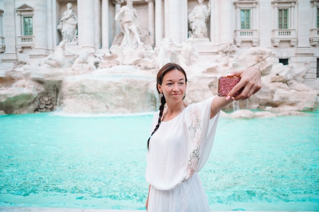 Jolie femme à la recherche de la fontaine de Trevi lors de son voyage à Rome, en Italie. Fille profiter de ses vacances en Europe