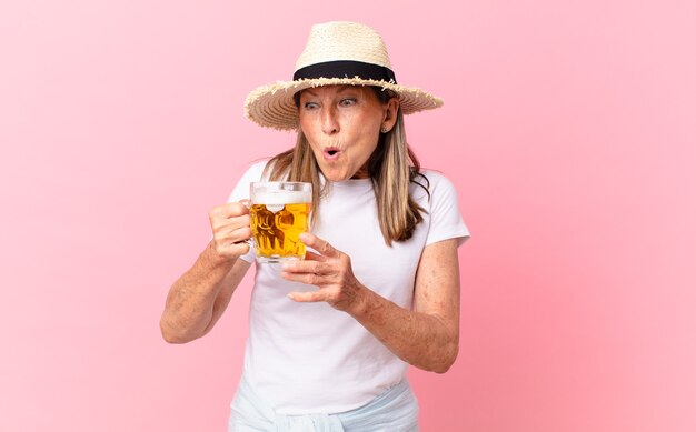 Jolie femme à la retraite d'âge moyen buvant une bière en vacances