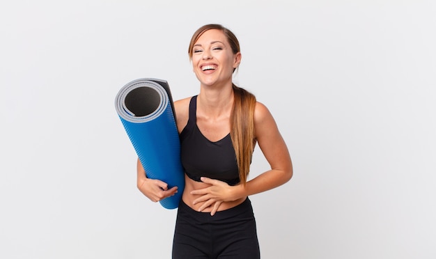 Jolie femme riant aux éclats d'une blague hilarante. notion de yoga