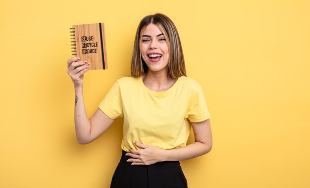 Jolie femme riant aux éclats d'une blague hilarante. recycler