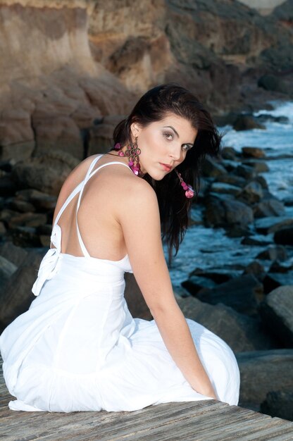 jolie femme en robe blanche au bord de la mer