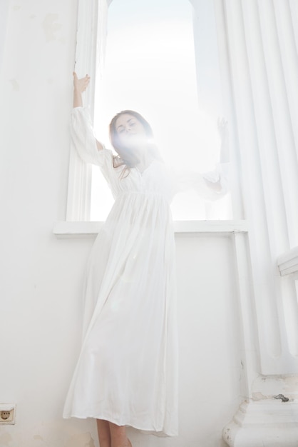 Jolie femme en robe blanche se tient près du luxe du soleil