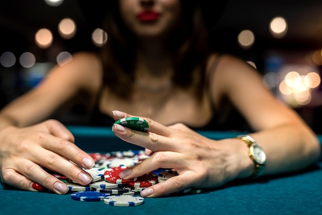 Jolie femme en robe noire du soir joue au poker dans le casino