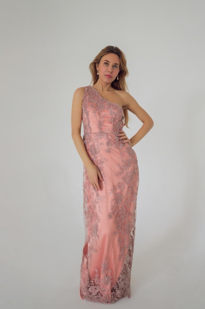 Jolie femme en robe rose sur fond blanc