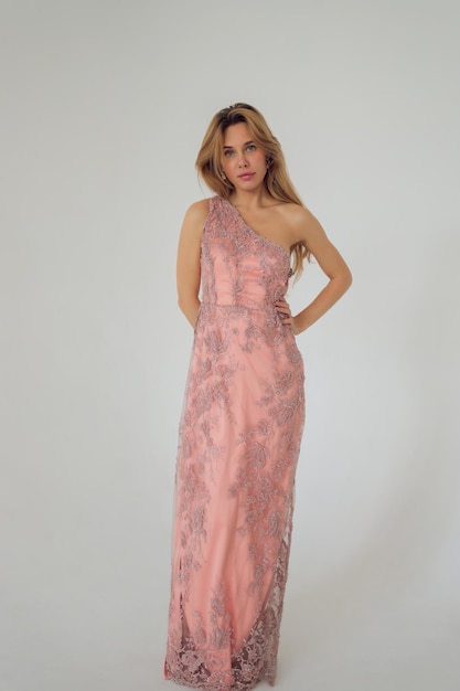 Jolie femme en robe rose sur fond blanc