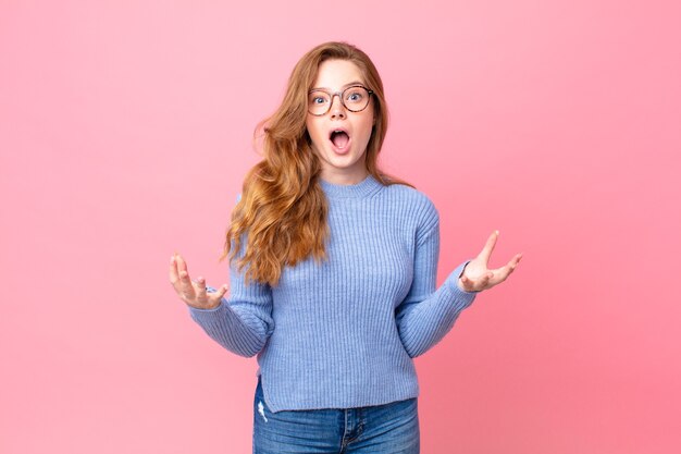 Jolie femme rousse émerveillée, choquée et étonnée d'une incroyable surprise