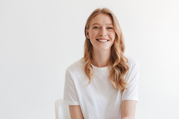 Jolie femme rousse isolée sur mur blanc