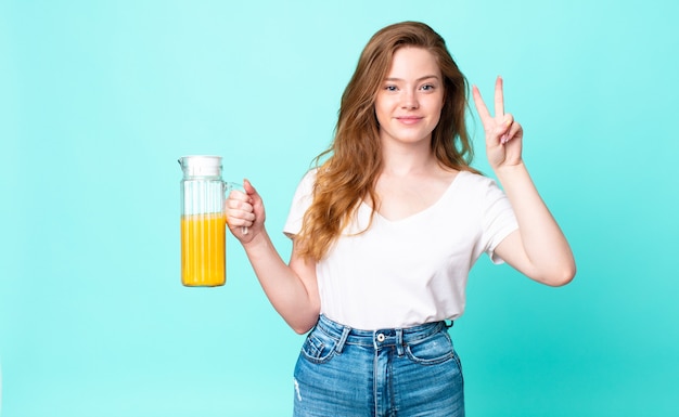 Jolie femme rousse. notion de jus d'orange