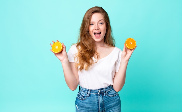 Jolie femme rousse. notion de jus d'orange