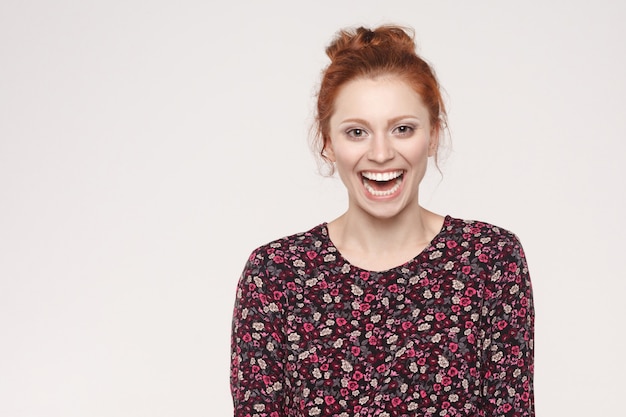 La jolie femme rousse avec une peau parfaitement propre souriant à la caméra avec heureuse et joyeuse. Studio isolé tourné sur fond gris.