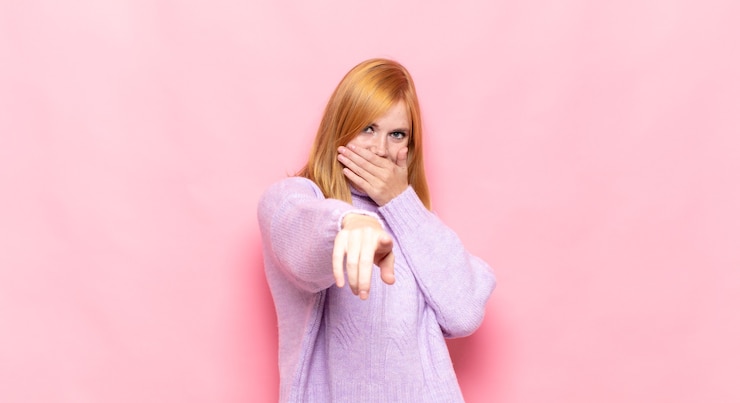 Photo jolie femme rousse se moquant de vous, pointant vers la caméra et se moquant ou se moquant de vous