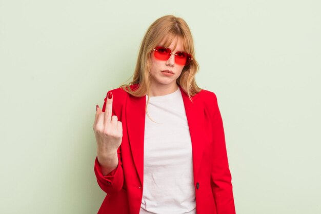 Jolie femme rousse se sentant en colère, agacée, rebelle et agressive. concept de femme d'affaires cool