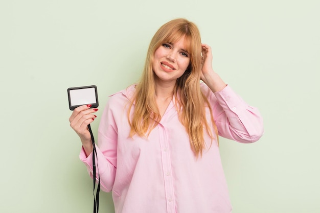 Jolie femme rousse se sentant stressée anxieuse ou effrayée avec les mains sur la tête concept d'identification de passe d'accréditation