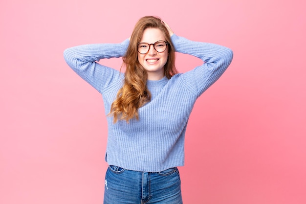 Jolie femme rousse se sentant stressée, anxieuse ou effrayée, les mains sur la tête