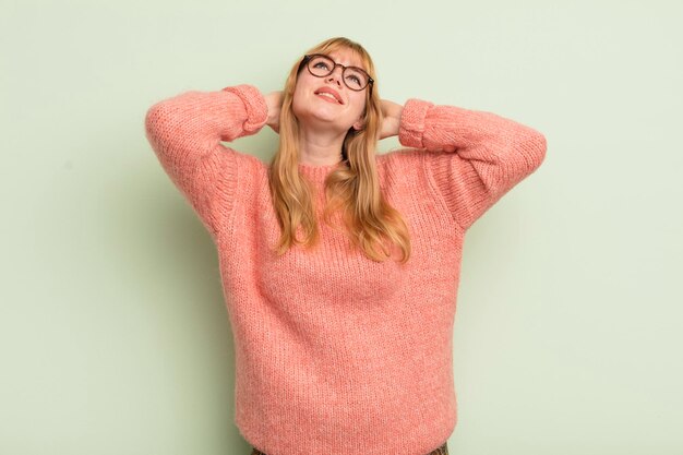 Jolie femme rousse souriante et se sentant détendue, satisfaite et insouciante, riant positivement et refroidissant