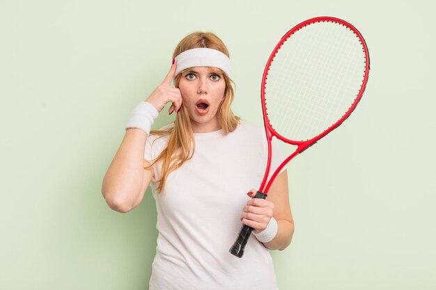 Jolie femme rousse à la surprise, réalisant une nouvelle pensée, idée ou concept. notion de tennis