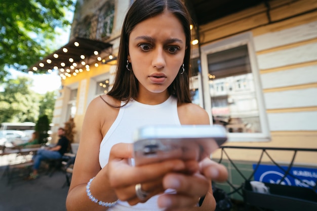 Jolie femme une rue urbaine pour lire un sms sur son téléphone portable