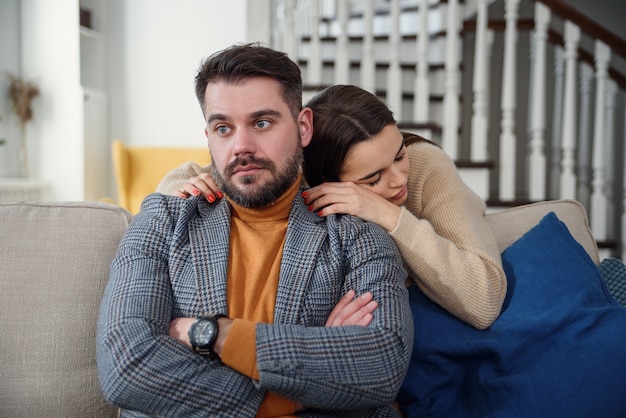 Jolie femme s'excusant auprès d'un homme frustré après une querelle, un petit ami doutant l'ignore, une petite amie se sentant coupable, lui demandant pardon, demandant pardon, admet une erreur, un regret, un couple ayant un problème